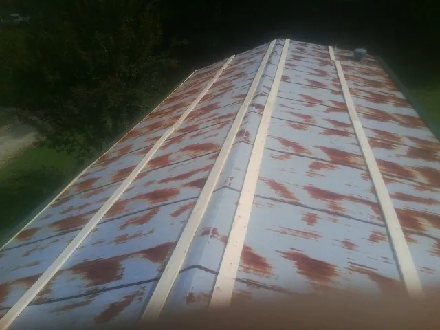 Rusted metal roof panels with new wood purlins before replacement — Storm Damage Roof Repair in Knox by Roofing Brothers