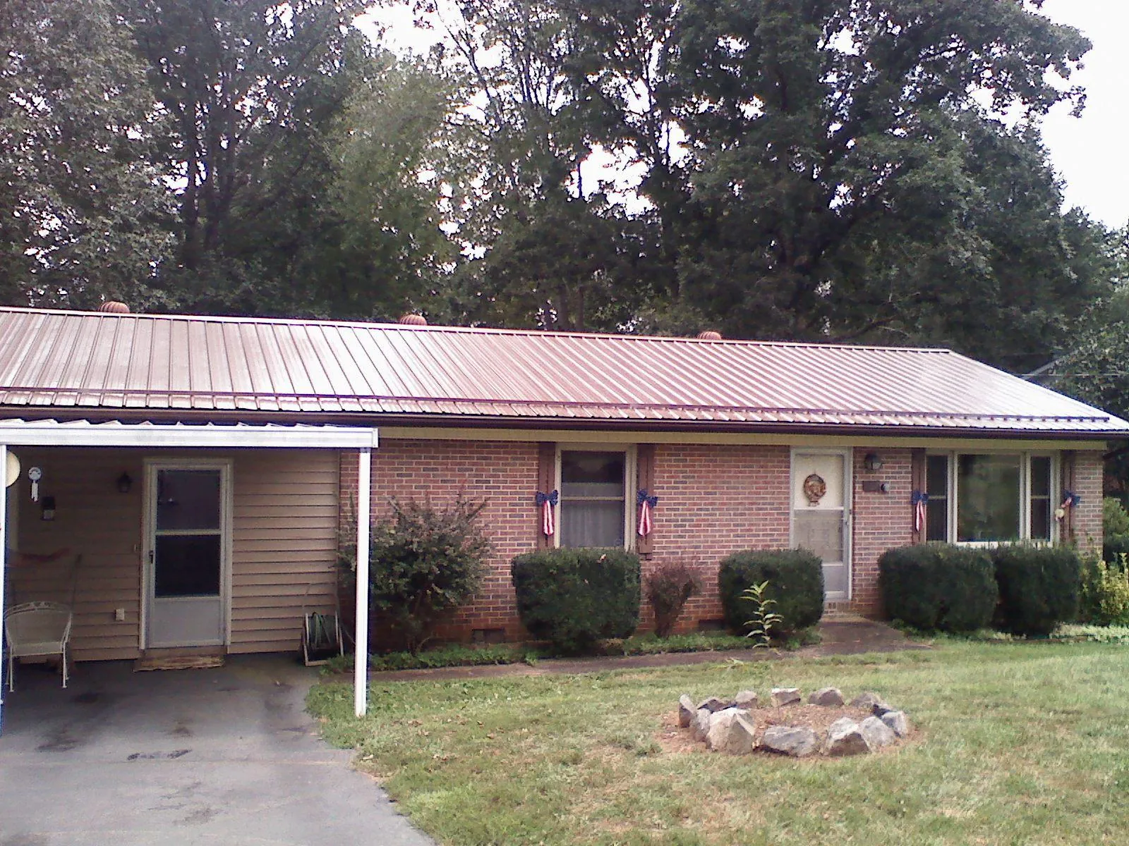 Bronze metal roof and carport on a brick ranch home — Roof Repair work by our crew in Knox